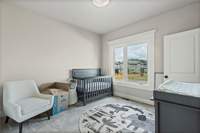 bedroom featuring a crib and light carpet