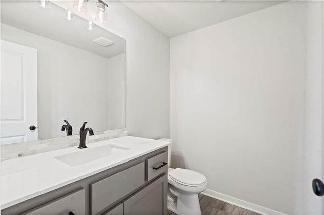 bathroom with hardwood / wood-style floors, vanity, and toilet