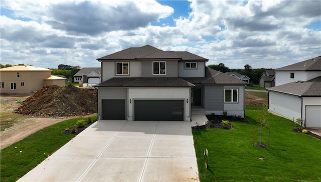 view of property featuring a front lawn and a garage