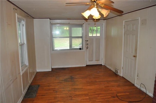 interior space with ceiling fan, dark hardwood / wood-style flooring, and ornamental molding