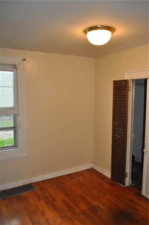 spare room with dark wood-type flooring