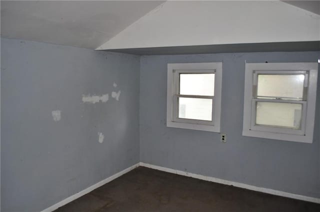 spare room featuring carpet floors and vaulted ceiling