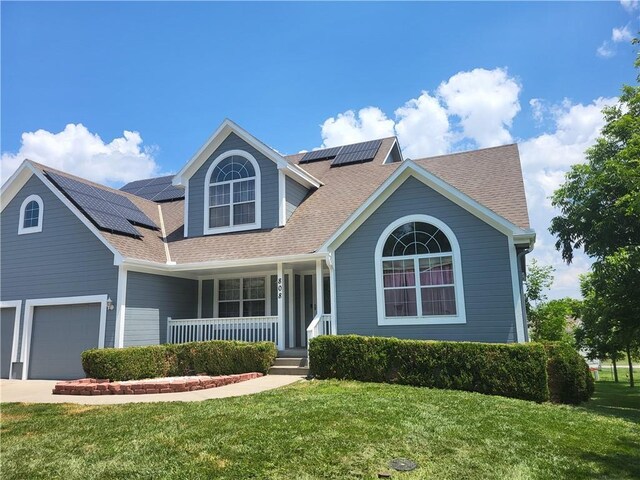 view of front of property with a front yard, solar panels, and a porch