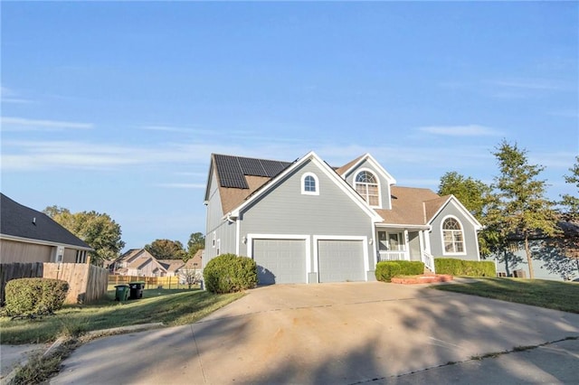 front of property with a garage, a front lawn, and solar panels