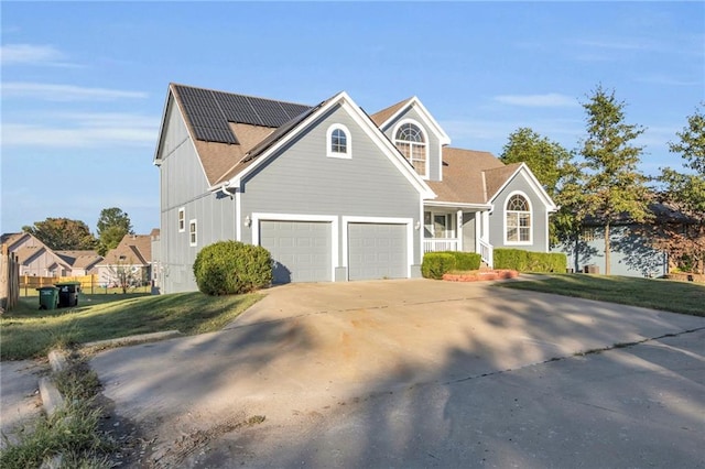 view of front of home featuring a garage, solar panels, and a front lawn