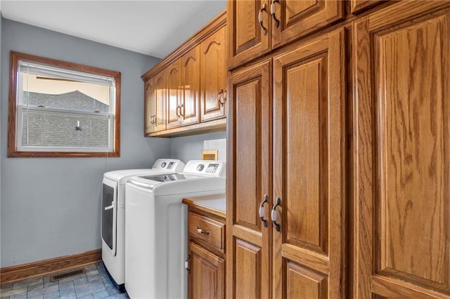 laundry room featuring washer and clothes dryer and cabinets