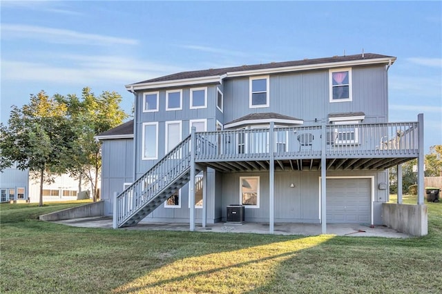 rear view of house with a garage, central AC, a deck, and a lawn