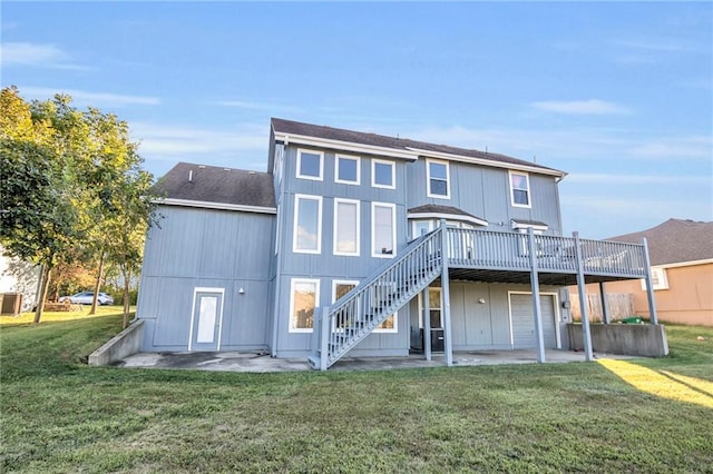 rear view of property featuring a wooden deck, a lawn, and a patio area