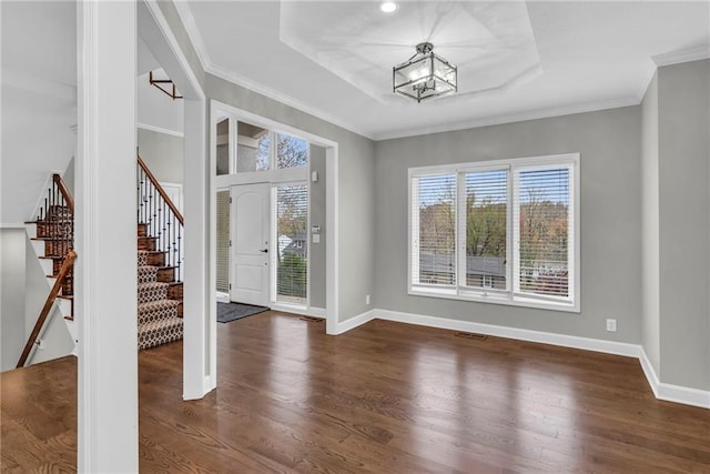 entrance foyer featuring a chandelier, dark hardwood / wood-style floors, and ornamental molding