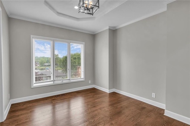 spare room with a chandelier, dark hardwood / wood-style flooring, and crown molding