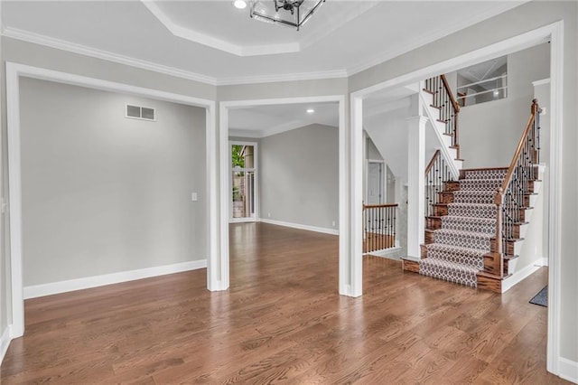 foyer entrance featuring a chandelier, hardwood / wood-style flooring, and ornamental molding