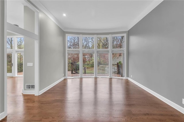 empty room with crown molding and wood-type flooring