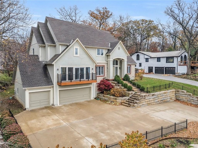 view of front facade featuring a garage, a balcony, and a front yard