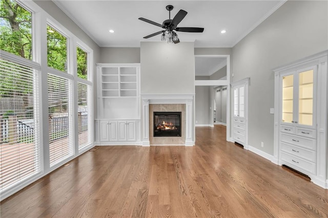 unfurnished living room with crown molding, a fireplace, ceiling fan, and light hardwood / wood-style floors