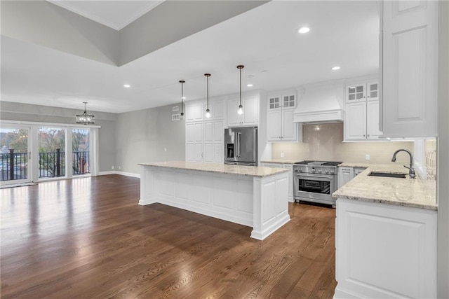 kitchen featuring premium range hood, stainless steel appliances, sink, pendant lighting, and a kitchen island