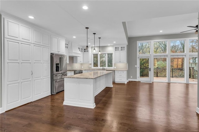 kitchen featuring white cabinetry, dark wood-type flooring, a kitchen island, and stainless steel appliances