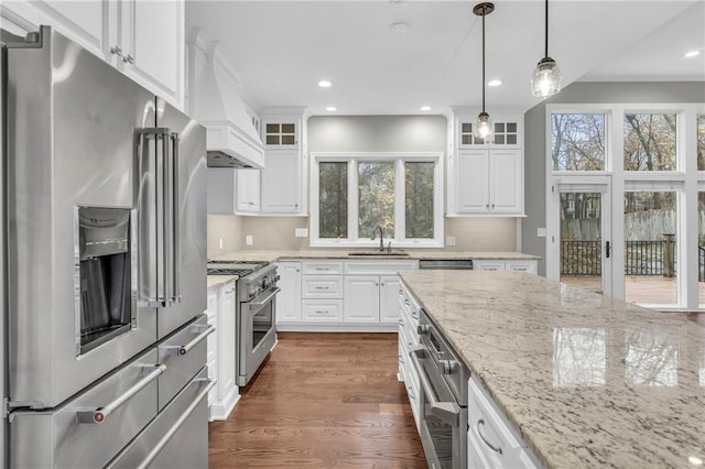 kitchen with custom range hood, premium appliances, and white cabinetry