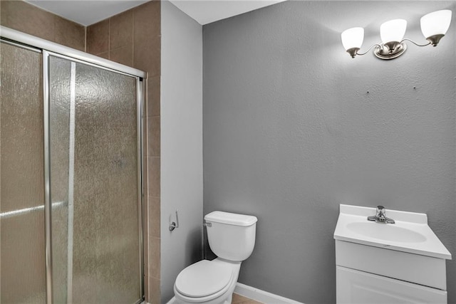 bathroom featuring vanity, toilet, and a shower with shower door