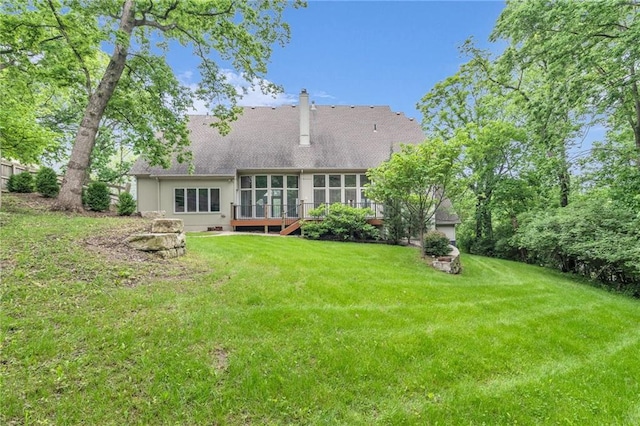 back of property with a sunroom and a yard