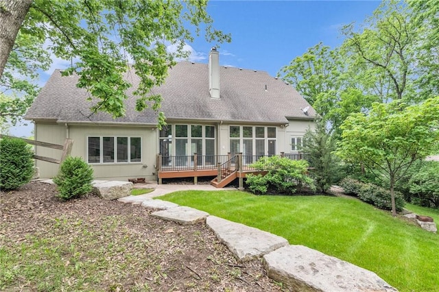 back of property featuring a sunroom, a yard, and a wooden deck