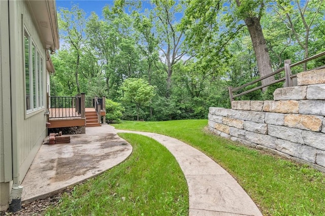 view of yard featuring a patio area and a wooden deck