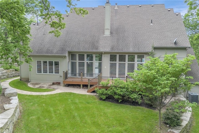 rear view of house featuring a deck, cooling unit, and a lawn