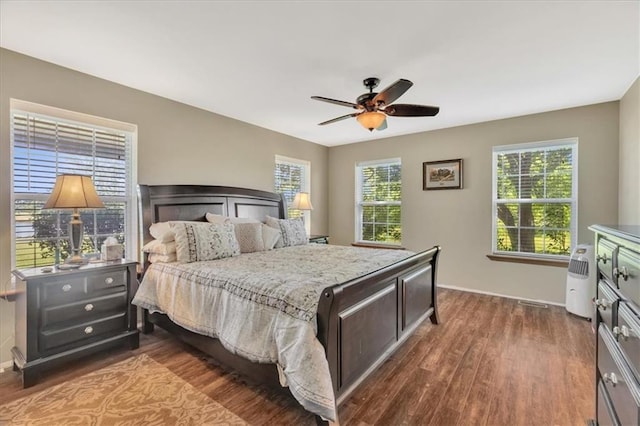 bedroom with ceiling fan and dark hardwood / wood-style flooring