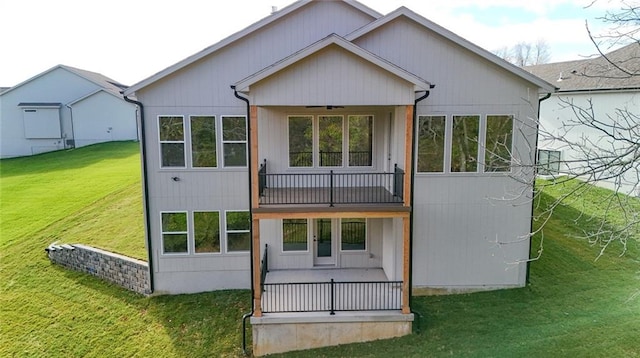 rear view of property featuring ceiling fan and a yard