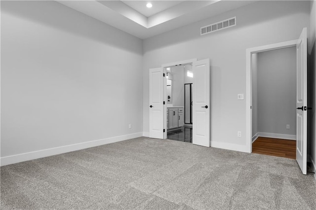 unfurnished bedroom featuring carpet flooring and ensuite bath