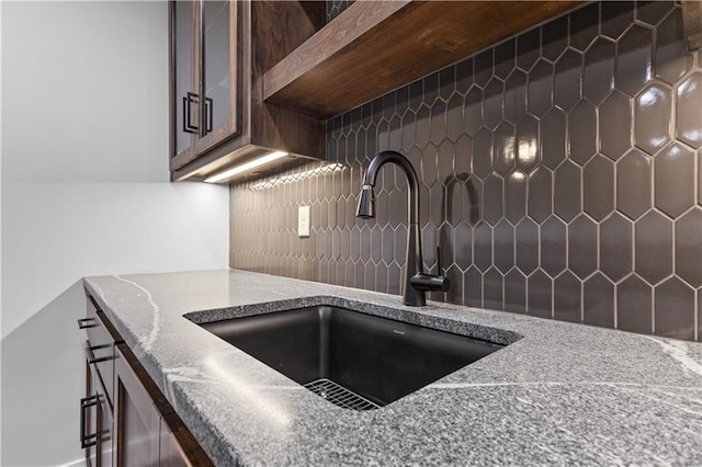 details featuring sink, tasteful backsplash, and stone counters