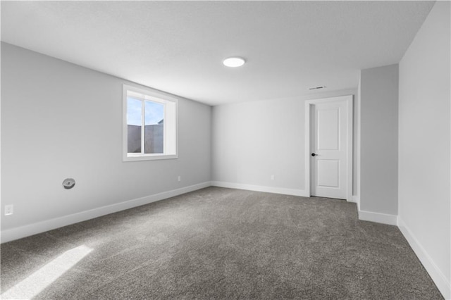 spare room with dark carpet