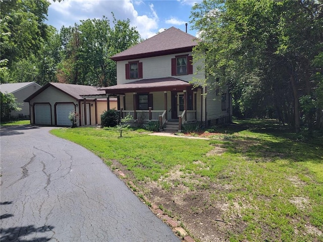 view of front of property with a front yard, a garage, an outdoor structure, and covered porch