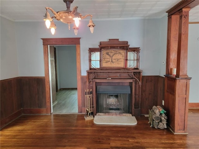 unfurnished living room with dark wood-type flooring, ornamental molding, and decorative columns