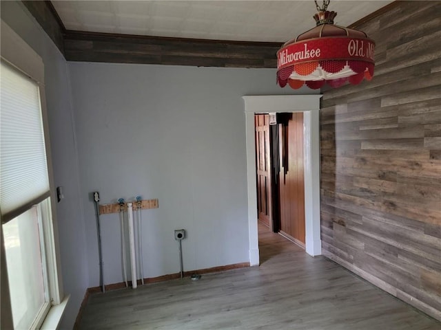 empty room featuring wood-type flooring and beamed ceiling