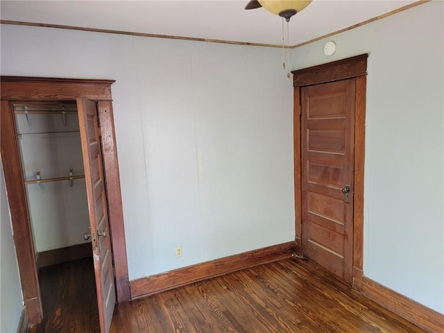 unfurnished bedroom featuring dark wood-type flooring and ceiling fan