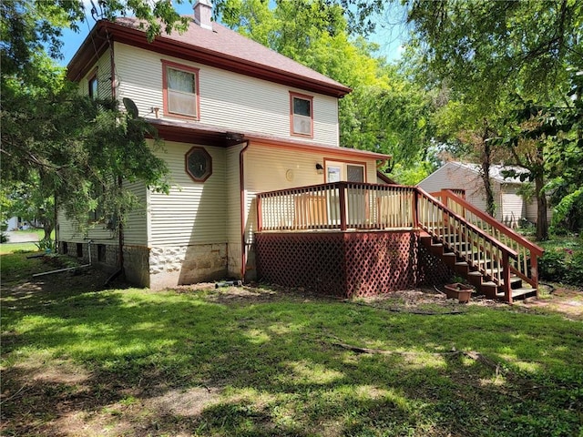 rear view of house with a wooden deck and a yard