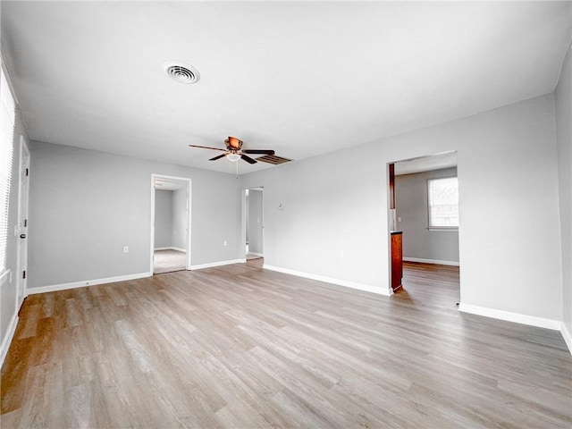 unfurnished room featuring light wood-style floors, visible vents, ceiling fan, and baseboards