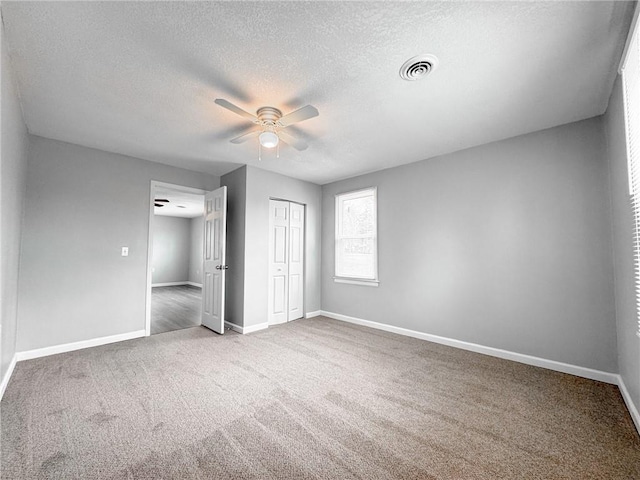 unfurnished bedroom featuring a closet, visible vents, baseboards, and carpet flooring