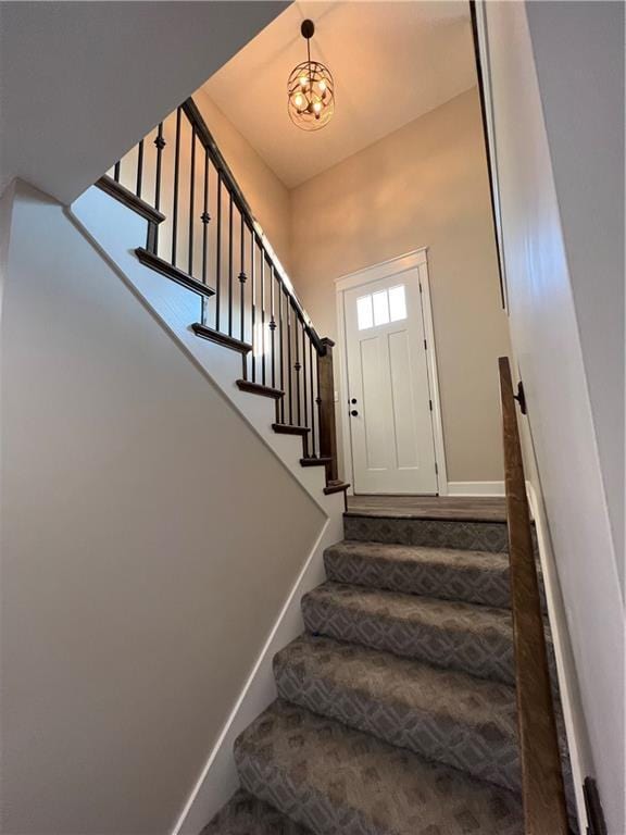 stairway with a chandelier and baseboards