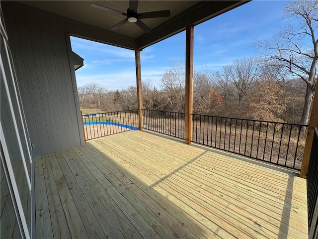 wooden terrace with ceiling fan and a covered pool