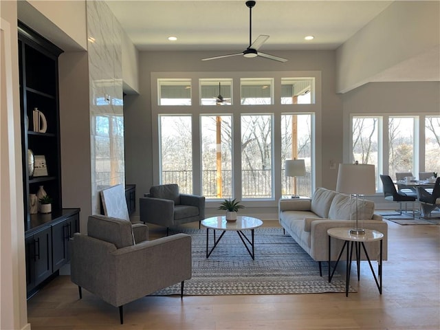 living room featuring a wealth of natural light, ceiling fan, and light hardwood / wood-style flooring