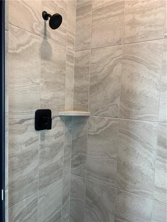 interior details featuring tiled shower