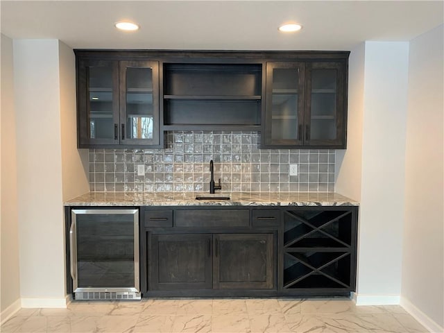 bar featuring sink, backsplash, wine cooler, and light stone counters