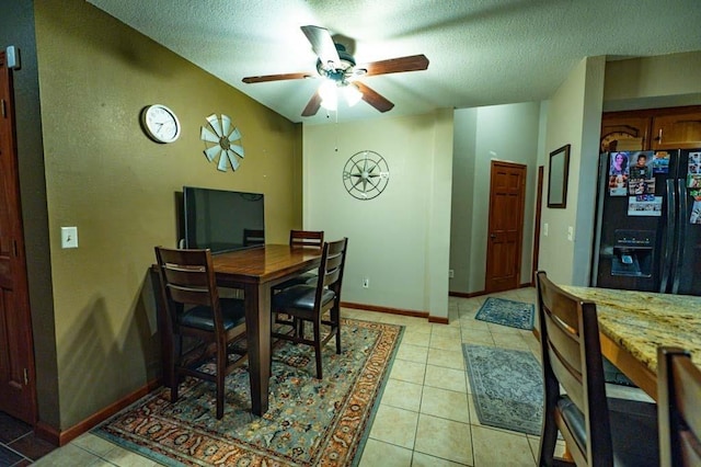 tiled dining room featuring ceiling fan and a textured ceiling