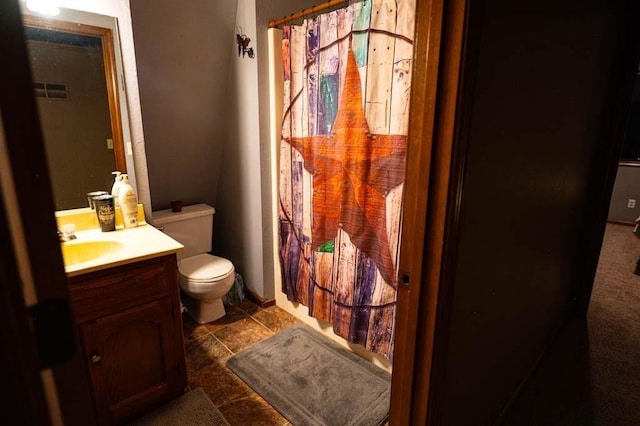 bathroom featuring vanity, toilet, and walk in shower