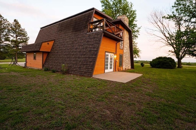 back of house with a lawn, a patio area, a balcony, and french doors