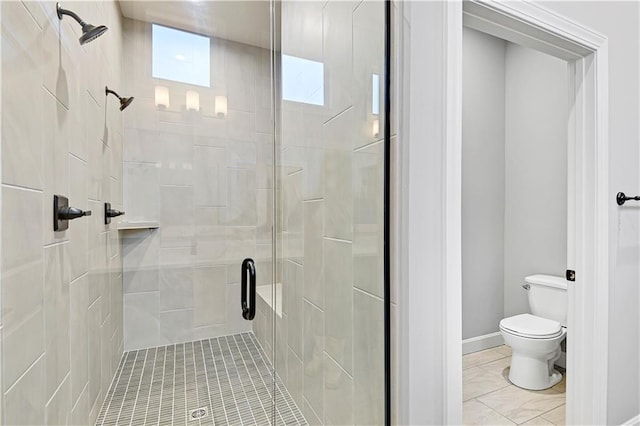 bathroom featuring tile patterned floors, toilet, and a shower with door