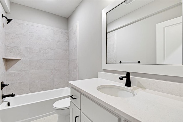 full bathroom featuring tile patterned flooring, tiled shower / bath combo, toilet, and vanity