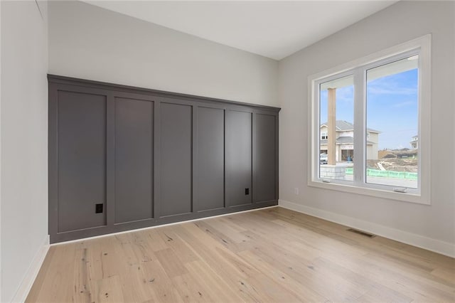 unfurnished room with light wood-type flooring