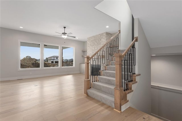 staircase featuring hardwood / wood-style flooring and ceiling fan